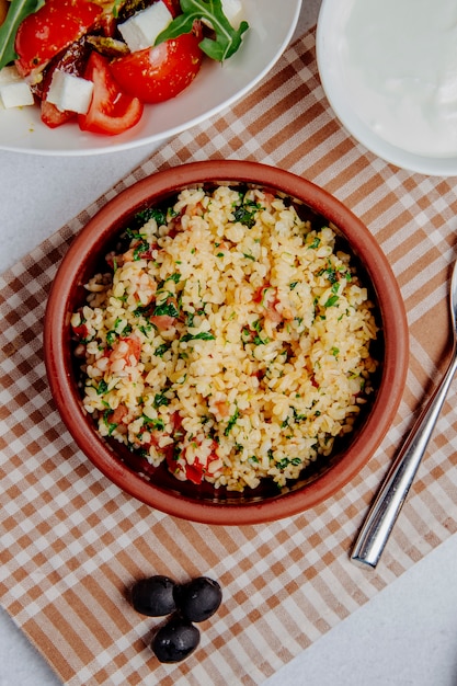 Foto gratuita vista dall'alto di bulgur con pomodori sul tavolo