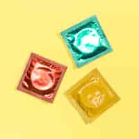 Free photo top view colourful condoms on yellow background