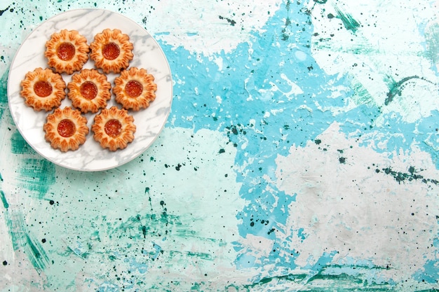 Free photo top view delicious cookies round formed with jam inside plate on the light-blue background cookie sugar sweet biscuit dough cake bake