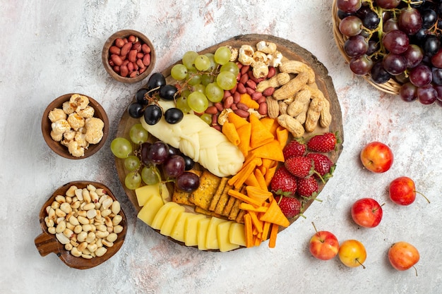 Free photo top view of delicious snacks cips grapes cheese and nuts on white surface