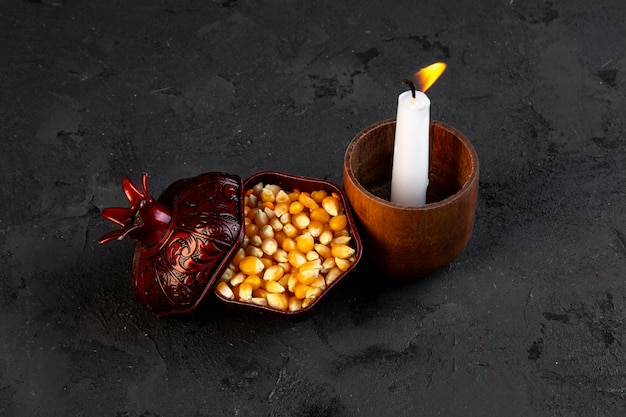 Free photo top view dried corn grains in a cup with a burning candle