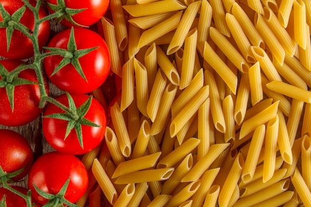 Free photo top view of macaroni next to tomatoes