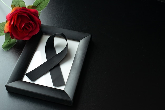 Top view of picture frame with black bow on dark wall