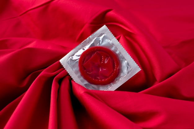 Free photo top view red condom on sheet