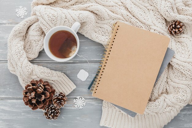 Top view tea cup with pine cones and agenda