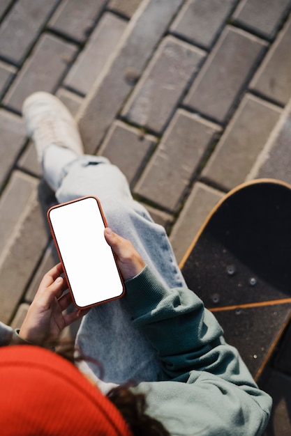 Free Photo top view of teenager outdoors using smartphone