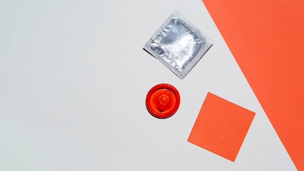 Free photo top view unwrapped red condom on white background