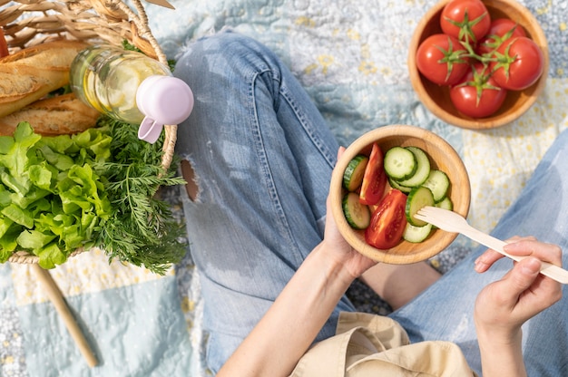 Foto gratuita insalatiera della tenuta della donna di vista superiore al picnic