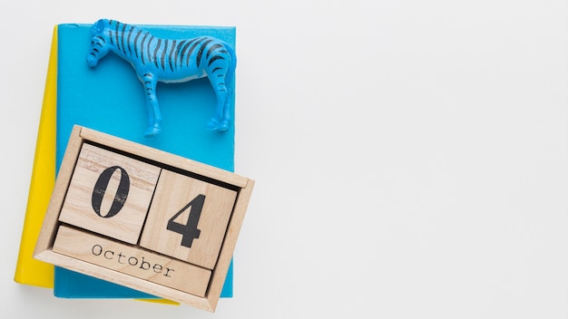 Free photo top view of wooden calendar with zebra figurine and book for animal day