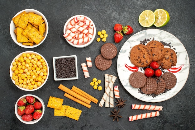 Free photo top view yummy choco biscuits with different snacks on dark background tea sweet cookie