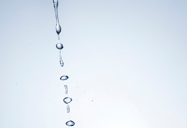 Free photo transparent liquid drops on light background with copy space