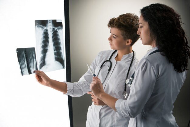 Free photo two attractive young doctors looking at x-ray results