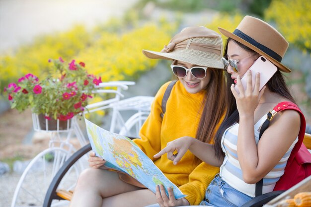 Free Photo two female tourists hold a map to find places.