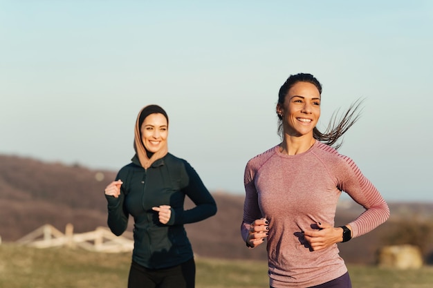 Free photo two happy sportswomen enjoying while jogging in the morning in nature