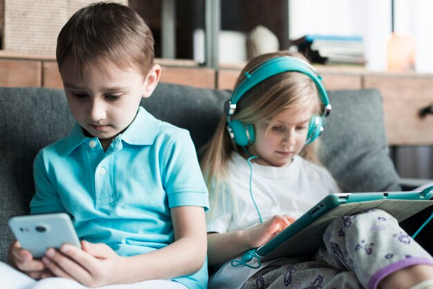 Two kids with tablet and smartphone