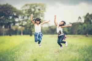 Free photo two little girls happy jump in the nature park