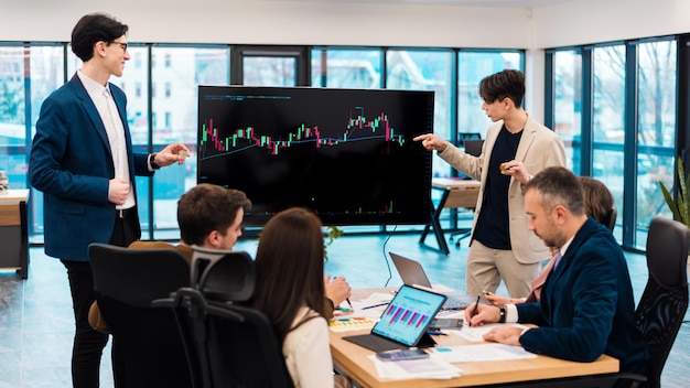 Foto gratuita due giovani lavoratori che conducono un incontro di lavoro sulle criptovalute in un ufficio