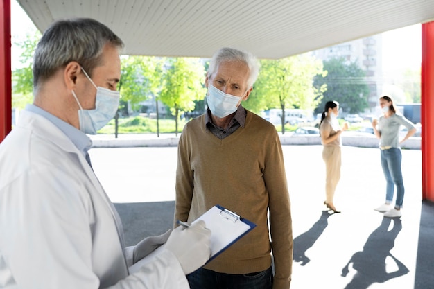 Free photo vaccination doctor at center filling patients information on notepad