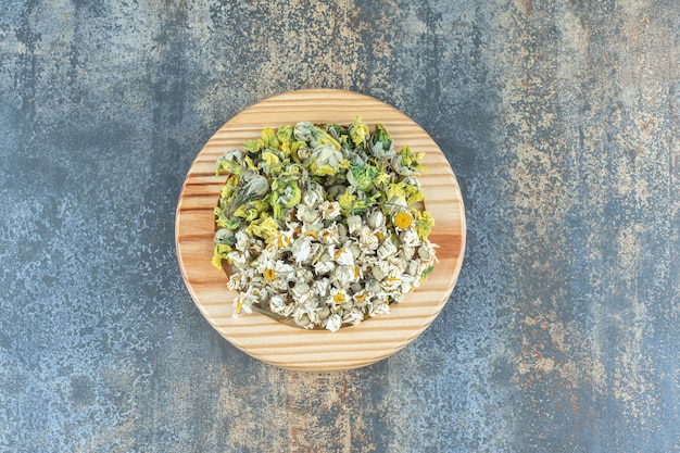 Free photo variety of dried flowers on wooden plate.