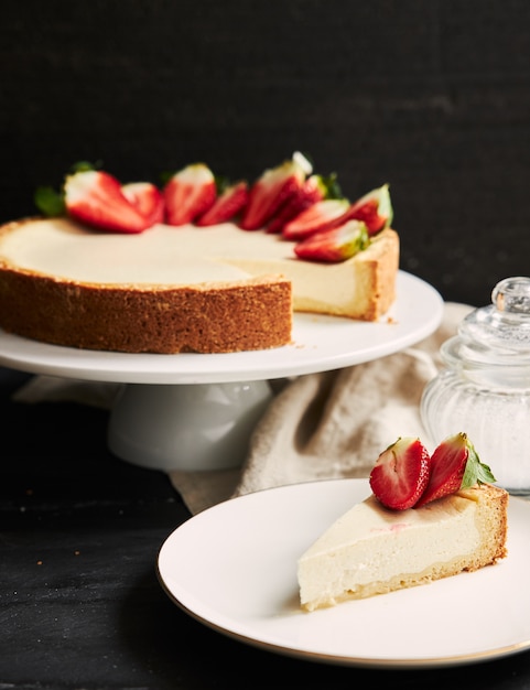 Free photo vertical closeup shot of strawberry cheesecake on white plate