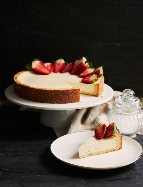 Free photo vertical closeup shot of strawberry cheesecake on white plate