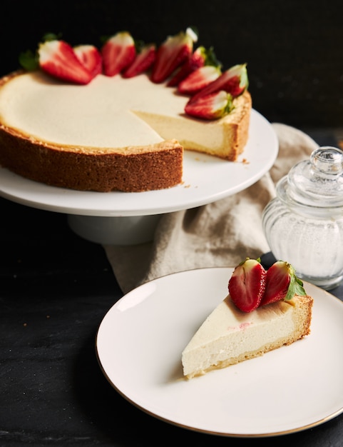 Free photo vertical closeup shot of strawberry cheesecake on a white plate