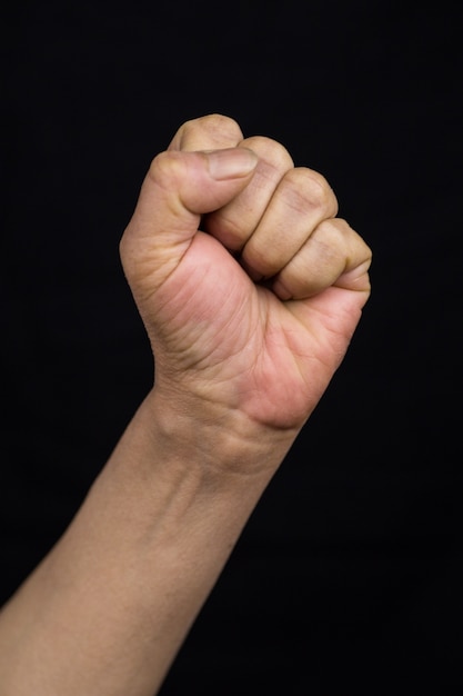 Foto gratuita colpo verticale di una donna asiatica che tiene il suo pugno come segno del concetto di empowerment delle donne