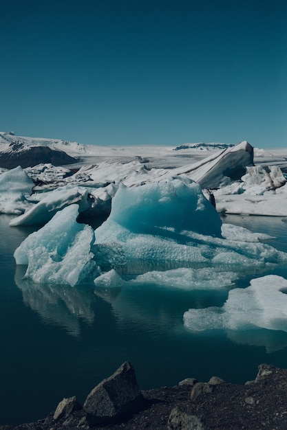Foto gratuita colpo verticale dei bellissimi iceberg sull'acqua catturati in islanda