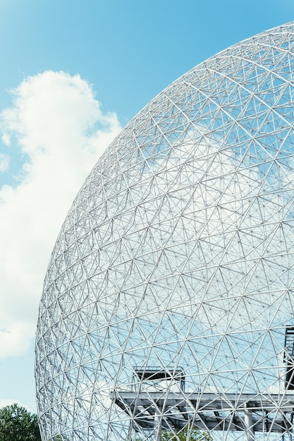 Free photo vertical shot of a globe-shaped construction under the bright cloudy sky