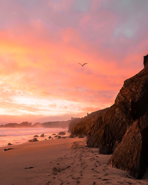 Free photo vertical shot of the mountains on the beach during sunset