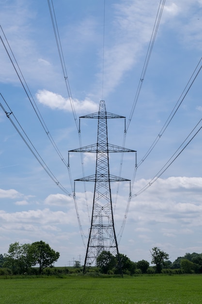 Free Photo vertical shot of an overhead electric power transmission tower standing in a field under the sky