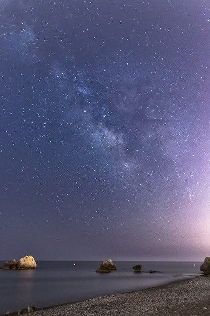 Free photo vertical shot of rocks on the torre de la sal beach in spain on a beautiful night