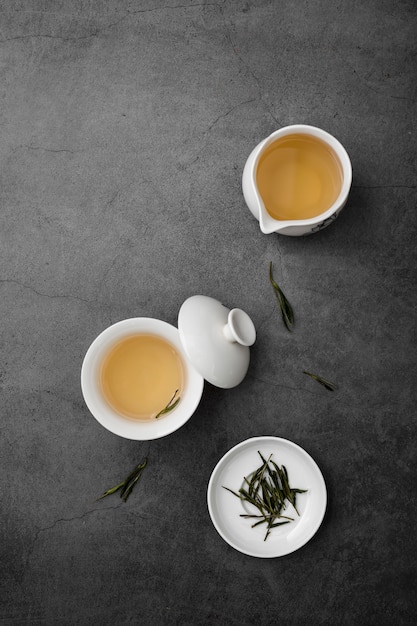 Free Photo above view arrangement with tea cups and herbs