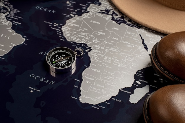 Free photo view of world travel map with compass and shoes