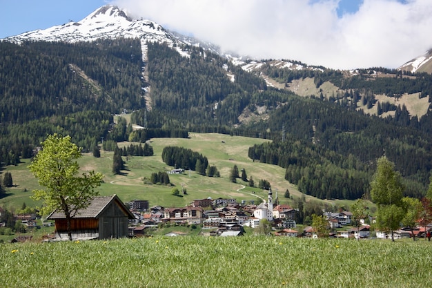 Foto gratuita un villaggio con molti edifici in un paesaggio montuoso circondato da alberi verdi