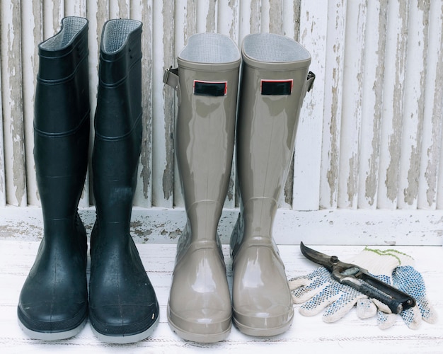 Free photo waterproof boots and pruner on white wood