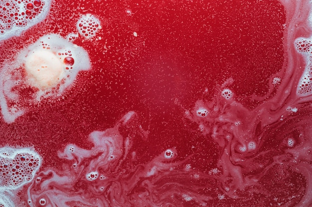 Free photo white paint and bubbles on red water