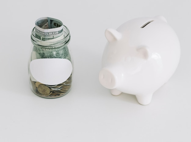 Free Photo white piggybank and an open coin jar on white background