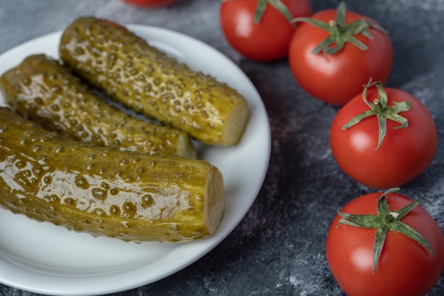 Free Photo a white plate of pickled cucumbers with tomatoes .