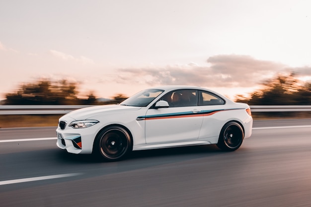 Free photo white sport sedan with colorful tuning on the road.