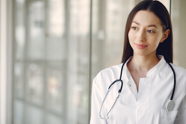 Foto gratuita medico della donna in un'uniforme bianca che sta in un corridoio