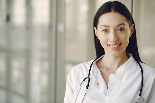 Foto gratuita medico della donna in un'uniforme bianca che sta in un corridoio