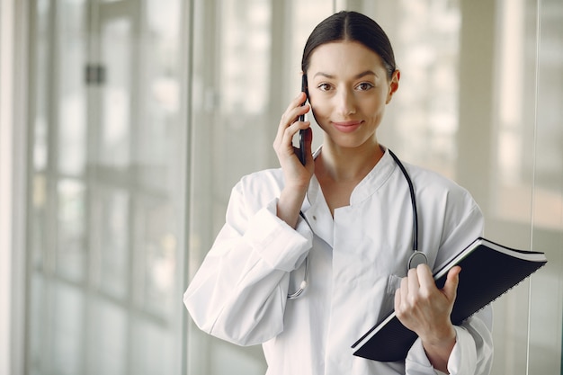 Foto gratuita medico della donna in un'uniforme bianca che sta in un corridoio