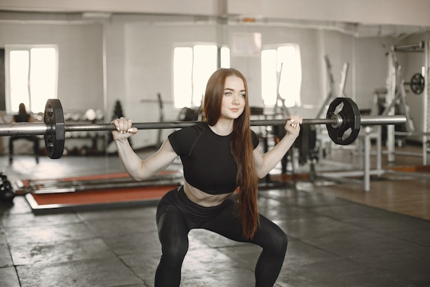 Free photo woman doing exercise with barbell. wearing black active wear.