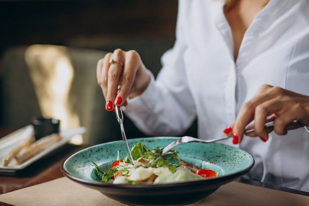 Foto gratuita donna che mangia una ciotola di insalata