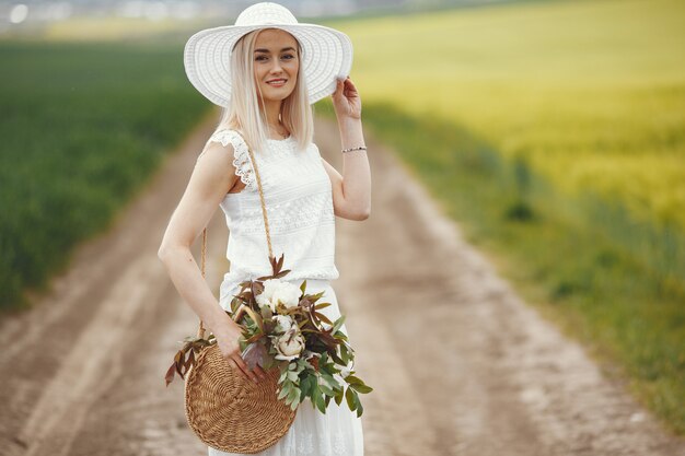 Free photo woman in elegant dress standing in a summer field