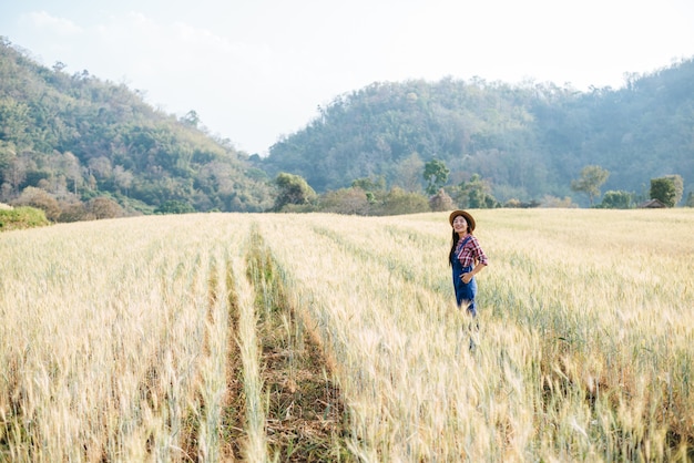 Free photo woman farmer with barley field harvesting season