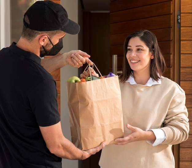 Free photo woman getting a food bag delivered