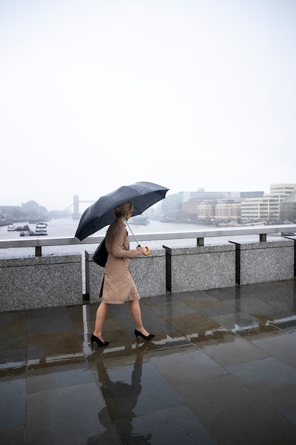 Free photo woman going out in the city while it rains