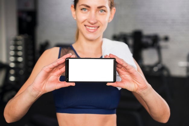 Free photo woman in gym with smartphone template